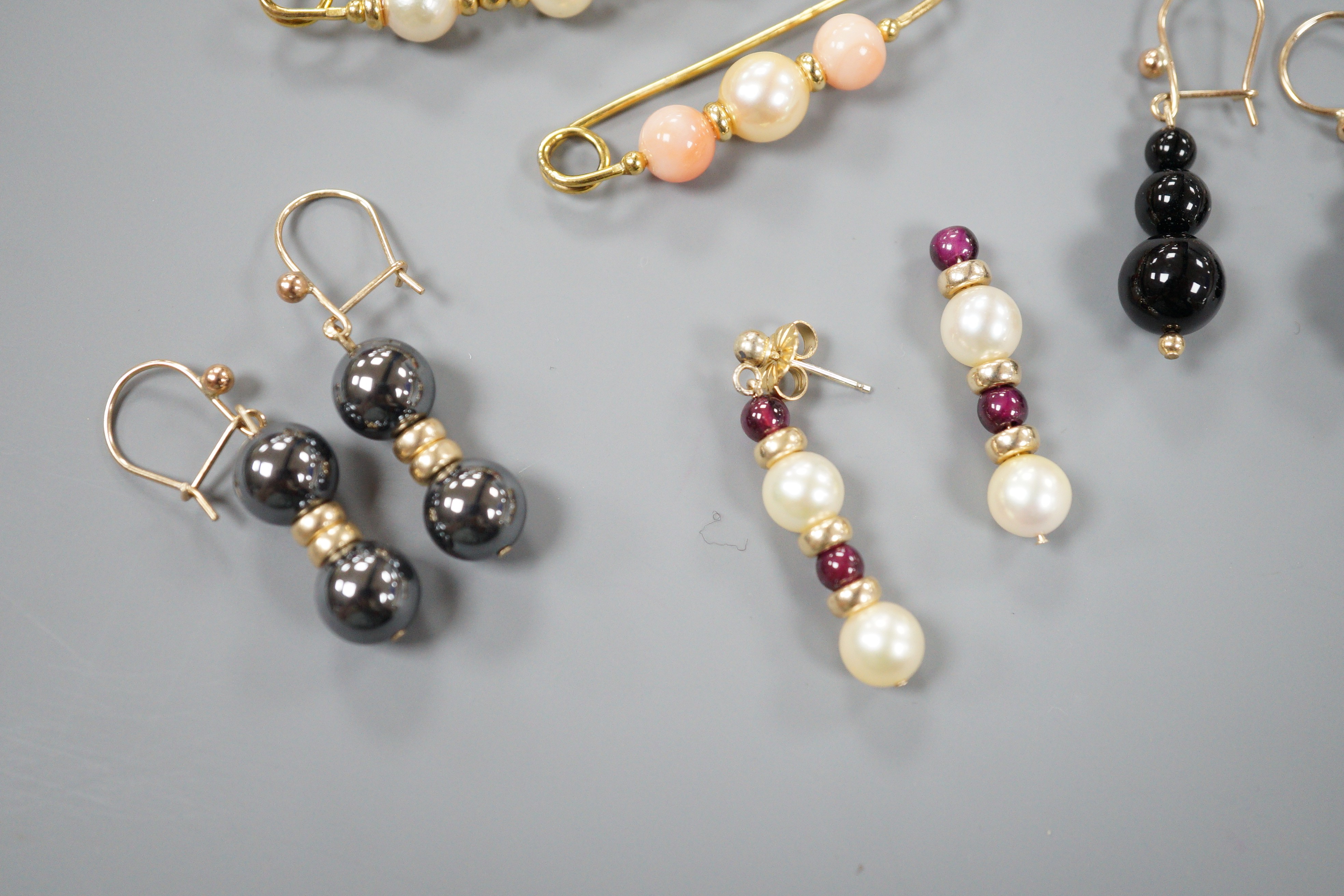 Three modern 9ct gold, cultured pearl and gem set brooches, largest 52mm and three modern pairs of yellow metal and gem set earrings, including hematite and 9k, gross weight 18.5 grams.